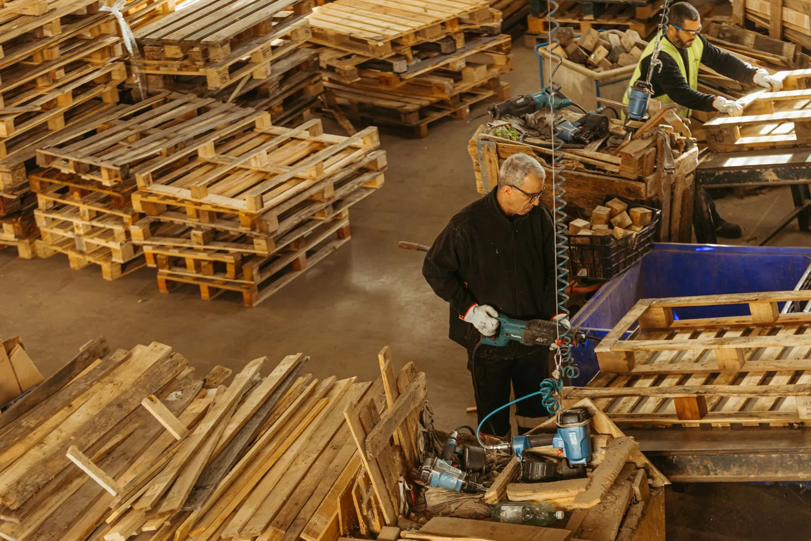 Operarios de ECO4US reparando palets de madera en la planta